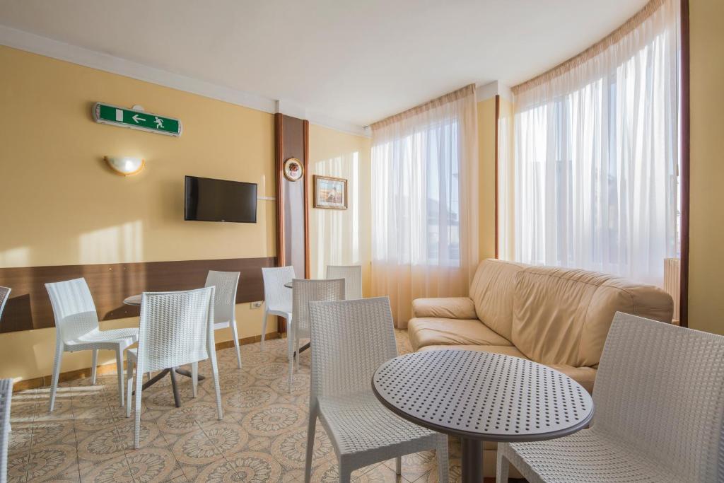 un salon avec un canapé, des tables et des chaises dans l'établissement Hotel Rosy, à Battipaglia