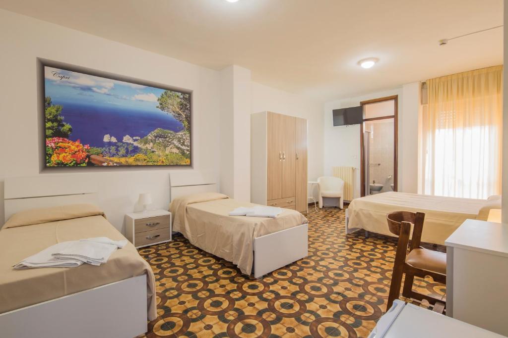 - une chambre d'hôtel avec 2 lits et une chambre avec un balcon dans l'établissement Hotel Rosy, à Battipaglia