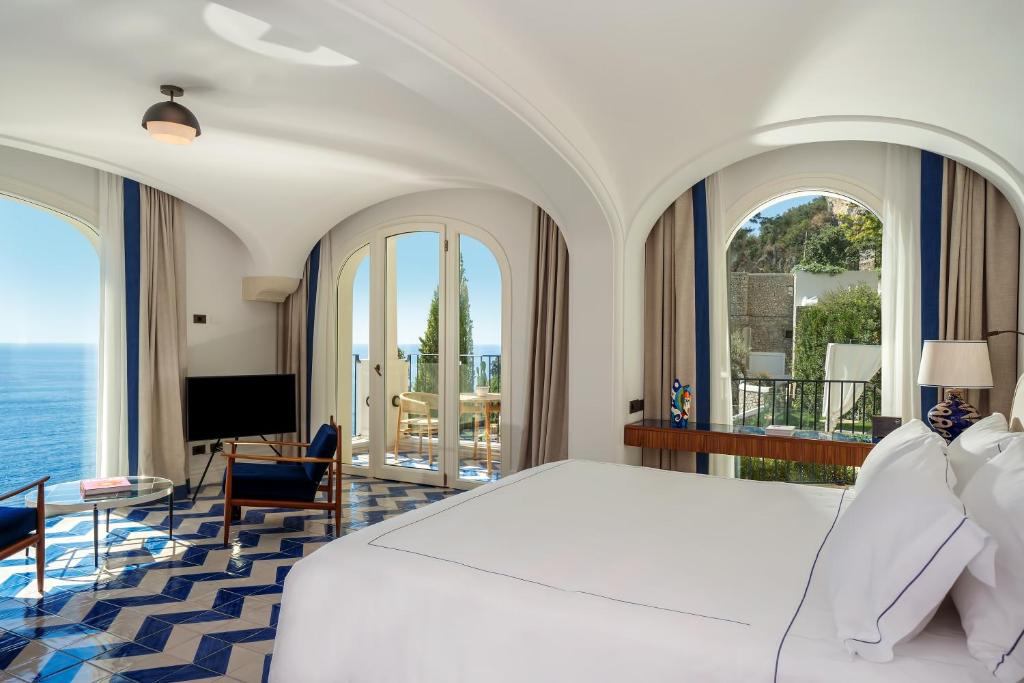 - une chambre avec un lit blanc et une vue sur l'océan dans l'établissement Borgo Santandrea, à Amalfi