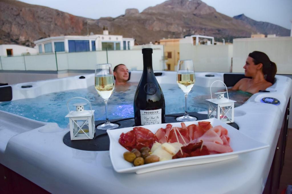 - une table avec une bouteille de vin et une assiette de nourriture dans l'établissement Hotel Sikania, à San Vito Lo Capo