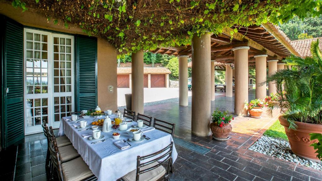 - une table à manger sur la terrasse d'une maison dans l'établissement Tenuta di Eupilio 18, Emma Villas, à Eupilio