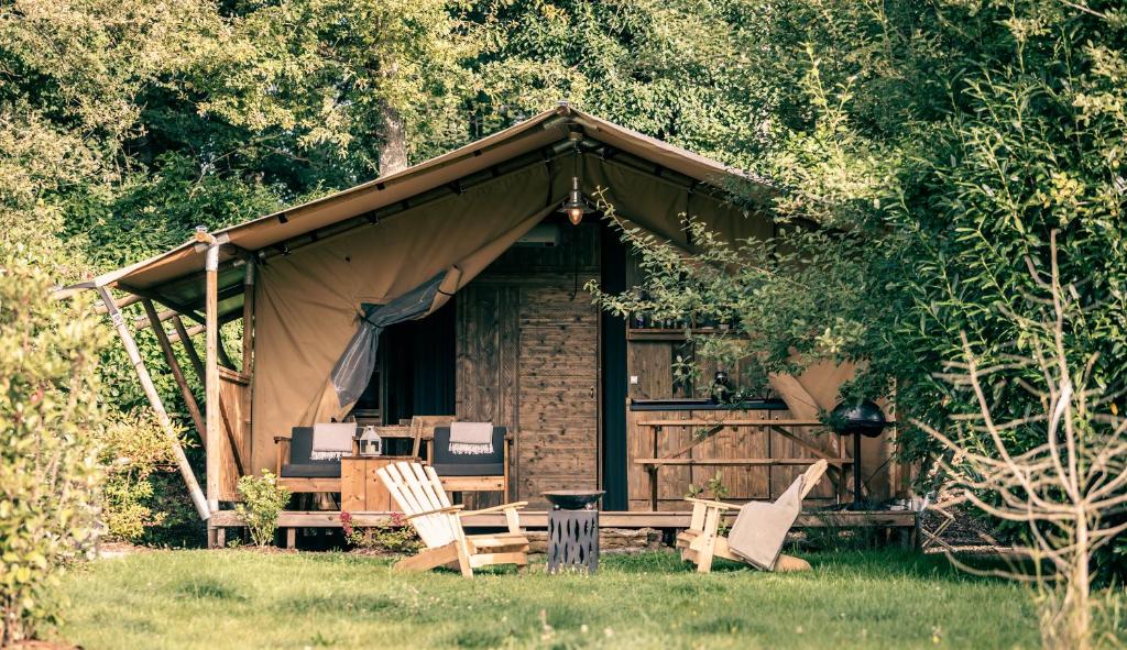 un groupe de chaises assises devant une cabine dans l'établissement Lodges des Grands Chênes, à Andelarrot