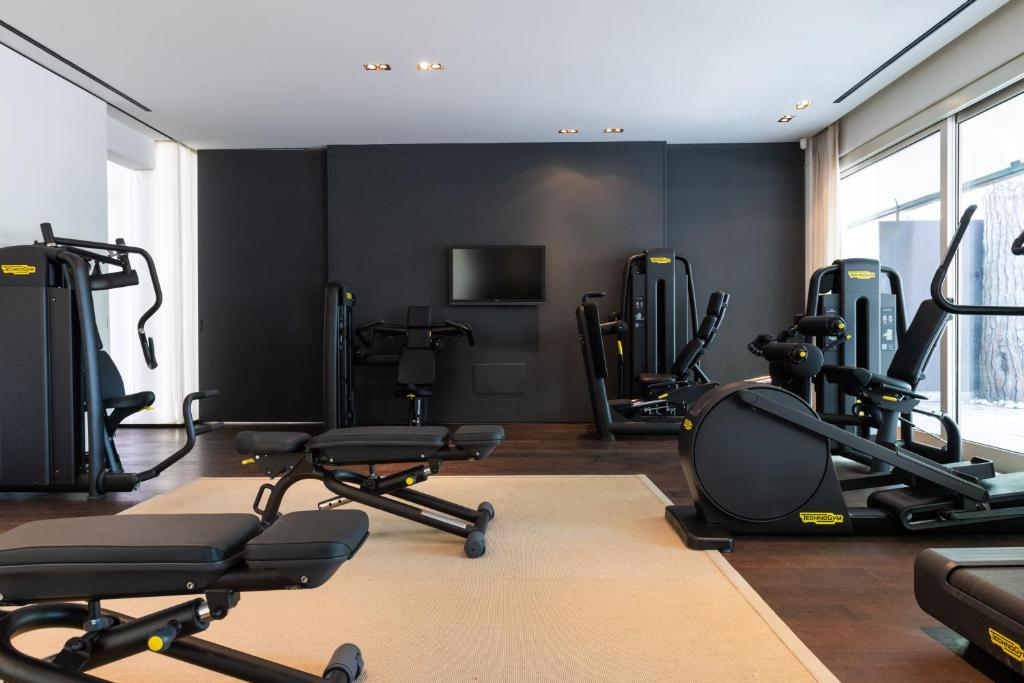 une salle de sport avec plusieurs tapis de course et vélos d'exercice dans l'établissement MarePineta Resort, à Milano Marittima