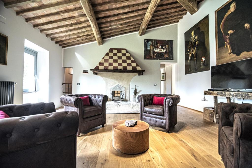 Elle comprend un salon doté d'un mobilier en cuir et d'une cheminée. dans l'établissement Tenuta San Galgano, à Monticiano