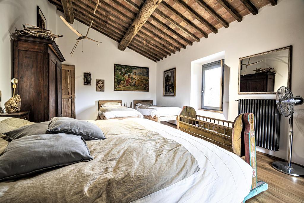 une chambre avec deux lits dans une pièce avec des plafonds en bois dans l'établissement Tenuta San Galgano, à Monticiano