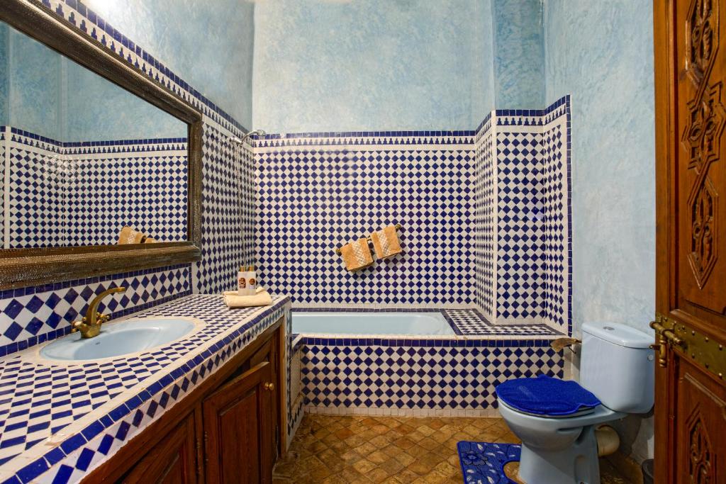 La salle de bains bleue et blanche est pourvue d'un lavabo et de toilettes. dans l'établissement Riad Lakhdar, à Marrakech