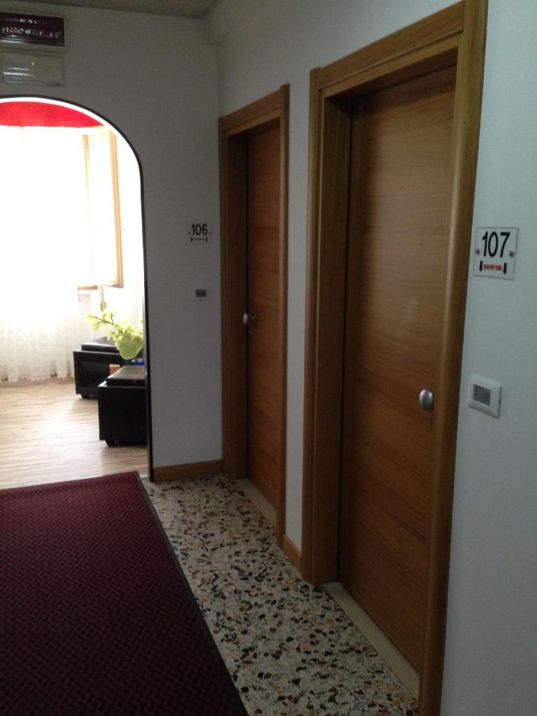 un couloir vide avec deux portes et un tapis dans l'établissement Hotel Villa Ginevra, à Cavallino-Treporti