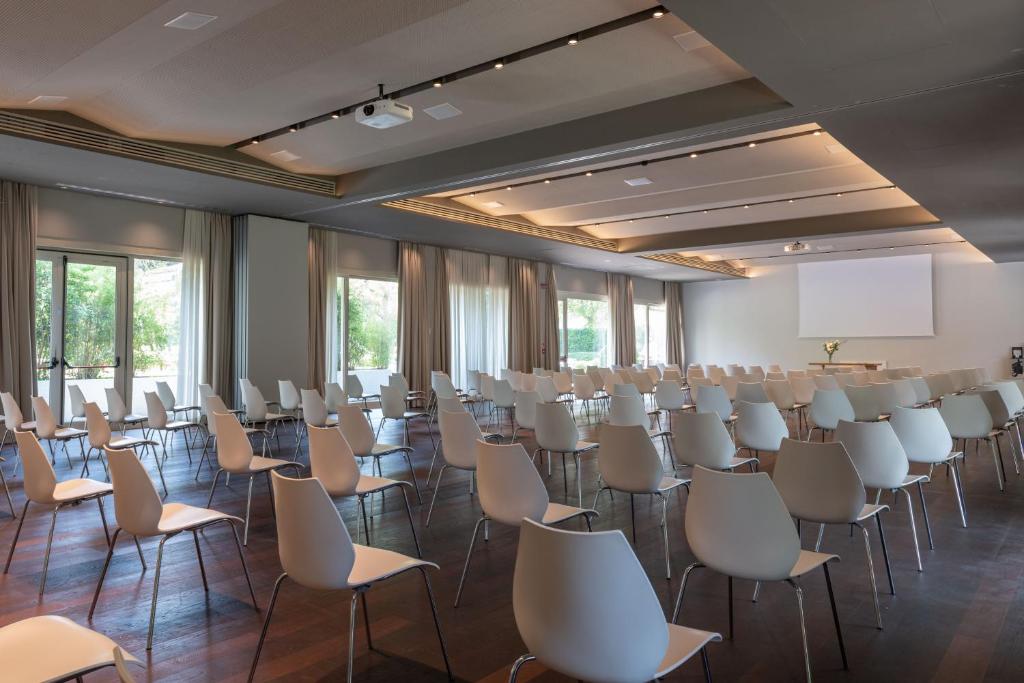 une chambre avec des rangées de chaises et un écran de projection dans l'établissement MarePineta Resort, à Milano Marittima 71 autres photos
