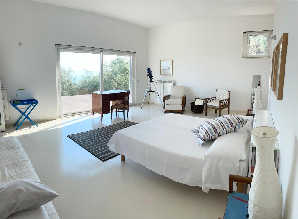- une chambre blanche avec un lit et un piano dans l'établissement Stunning Design Villa with unique 180º sea views, à Marina di San Vito
