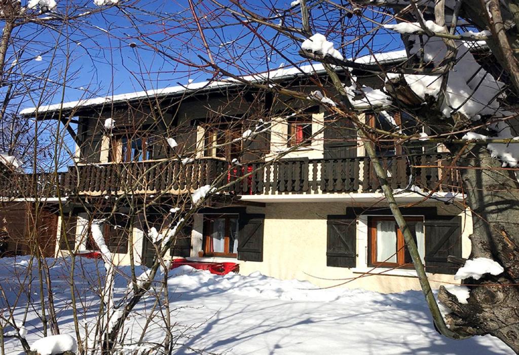 une maison avec un balcon dans la neige dans l'établissement la levanna, à Les Deux Alpes