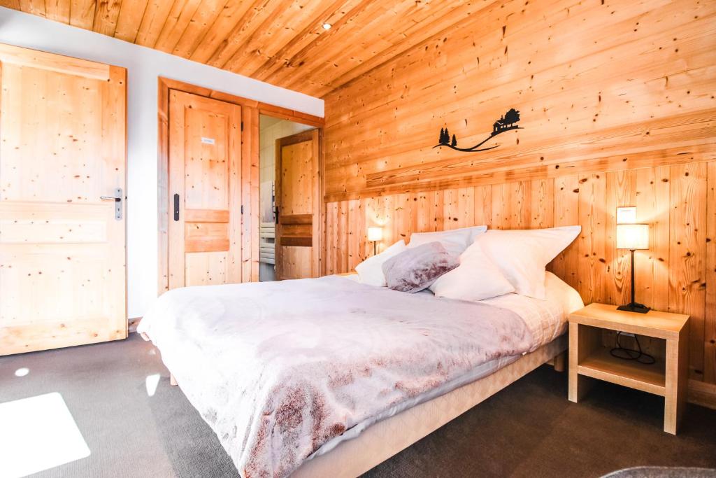 une chambre avec un lit dans un mur en bois dans l'établissement Vue panoramique sur les montagnes plein Sud - T2 Skis aux pieds, Piscine & Spa, à Flaine 37 autres photos