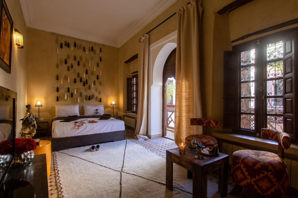 une chambre avec un lit, une chaise et des fenêtres dans l'établissement Riad Hizad, à Marrakech 37 autres photos