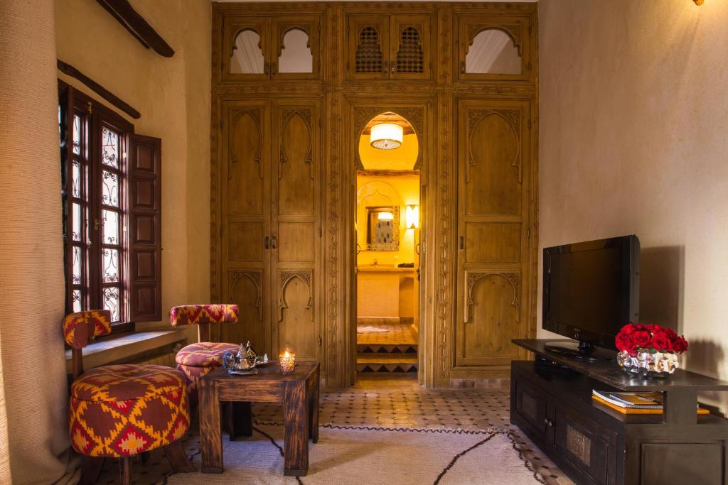 un salon avec une télévision et une chambre avec une porte dans l'établissement Riad Hizad, à Marrakech