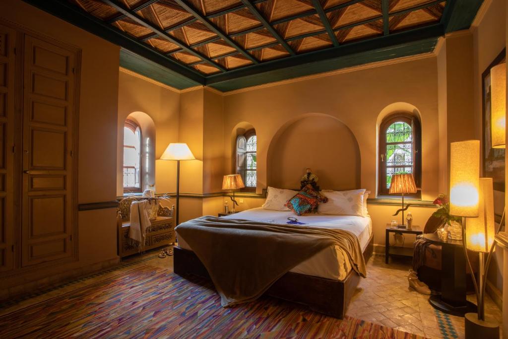 une chambre avec un lit et deux fenêtres dans l'établissement Riad Hizad, à Marrakech