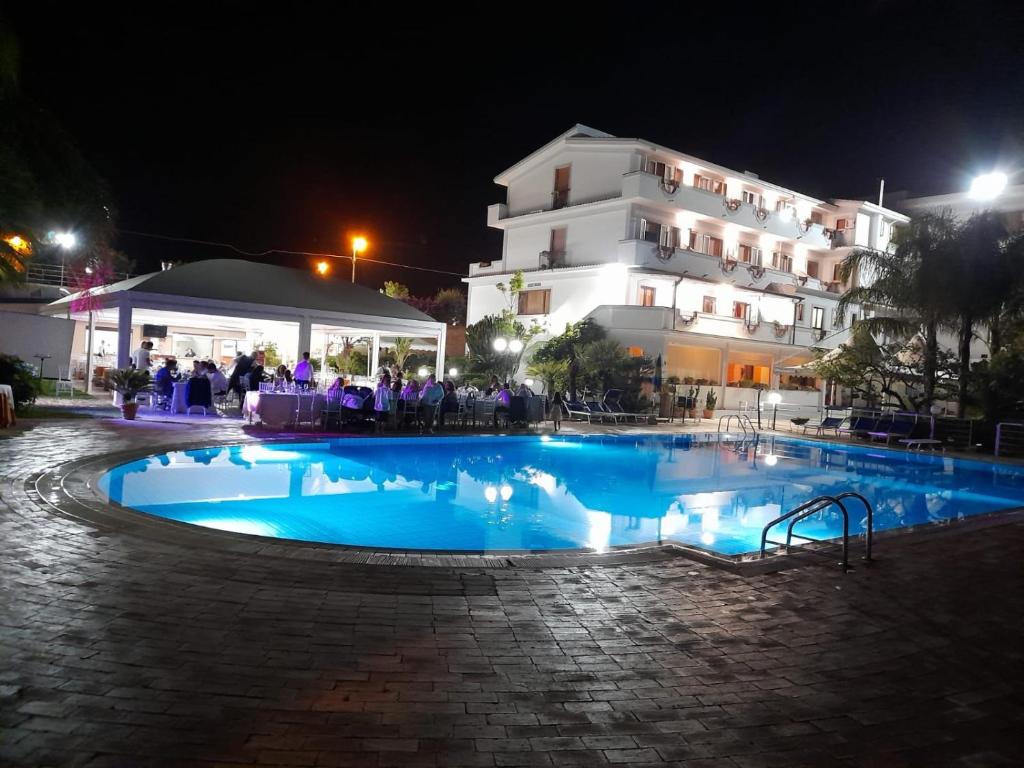 une piscine devant un immeuble la nuit dans l'établissement Hotel Il Corsaro, à Le Castella 13 autres photos