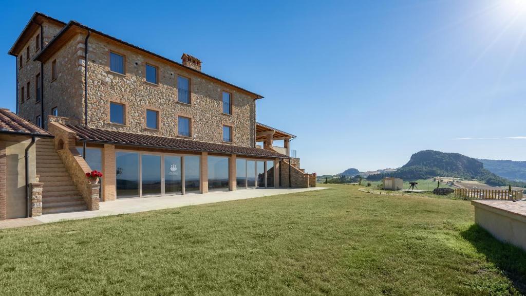 - une vue extérieure sur un bâtiment avec une grande cour dans l'établissement Il Poggiarellone 18, Emma Villas, à Volterra