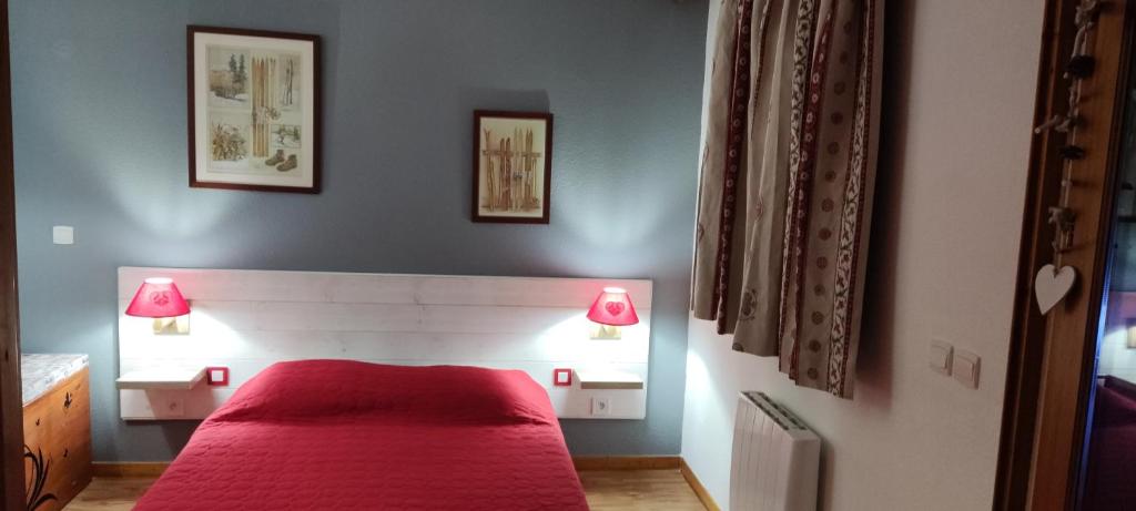 - une chambre avec un lit rouge et deux lampes dans l'établissement Residence la Dame Blanche, à Puy-Saint-Vincent