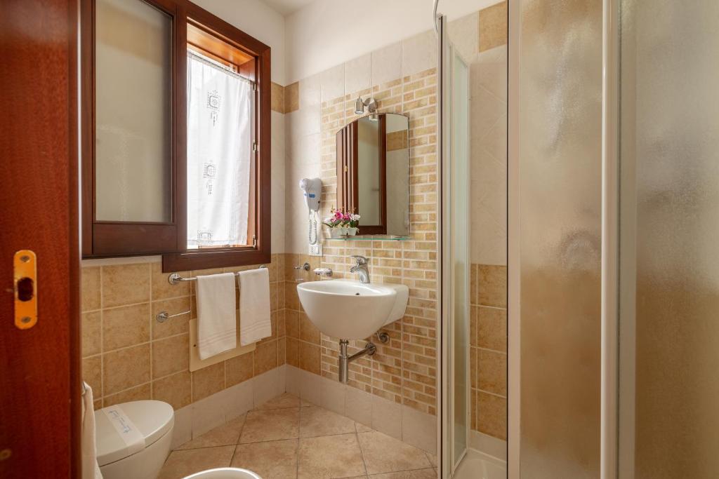 une salle de bain avec un lavabo, des toilettes et une douche dans l'établissement Hotel Sikania, à San Vito Lo Capo