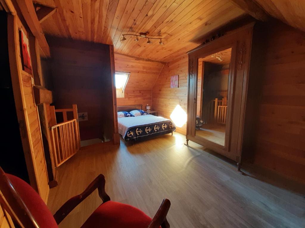 une chambre avec un lit dans une cabane en bois dans l'établissement Gite les Courtaillards, à Couches