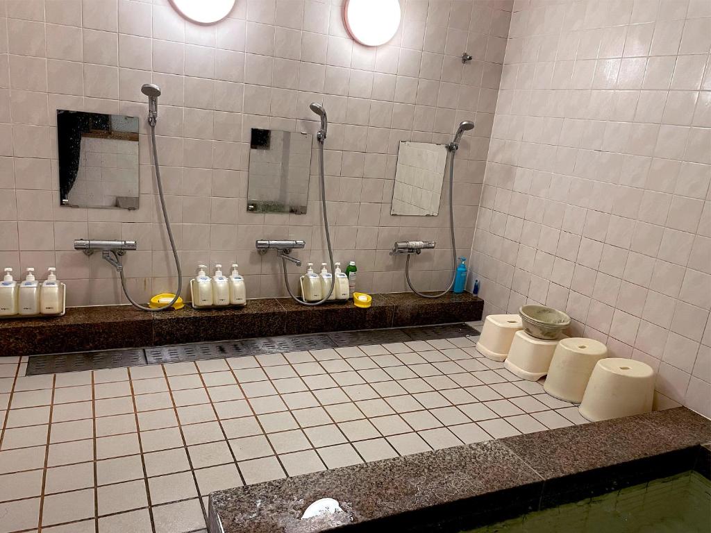 La salle de bains est pourvue de 2 douches, de 2 lavabos et de toilettes. dans l'établissement Business Ryokan Wakakusa, à Tsu