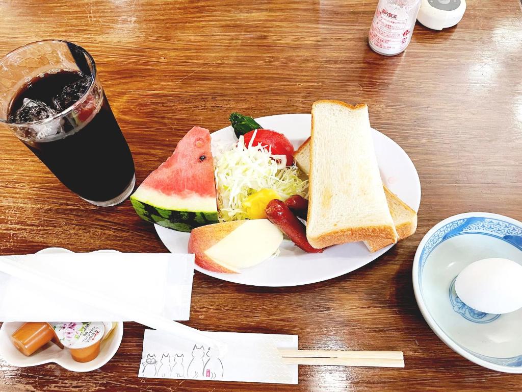 - une assiette de nourriture avec du pain, des fruits et une boisson dans l'établissement Business Ryokan Wakakusa, à Tsu 9 autres photos