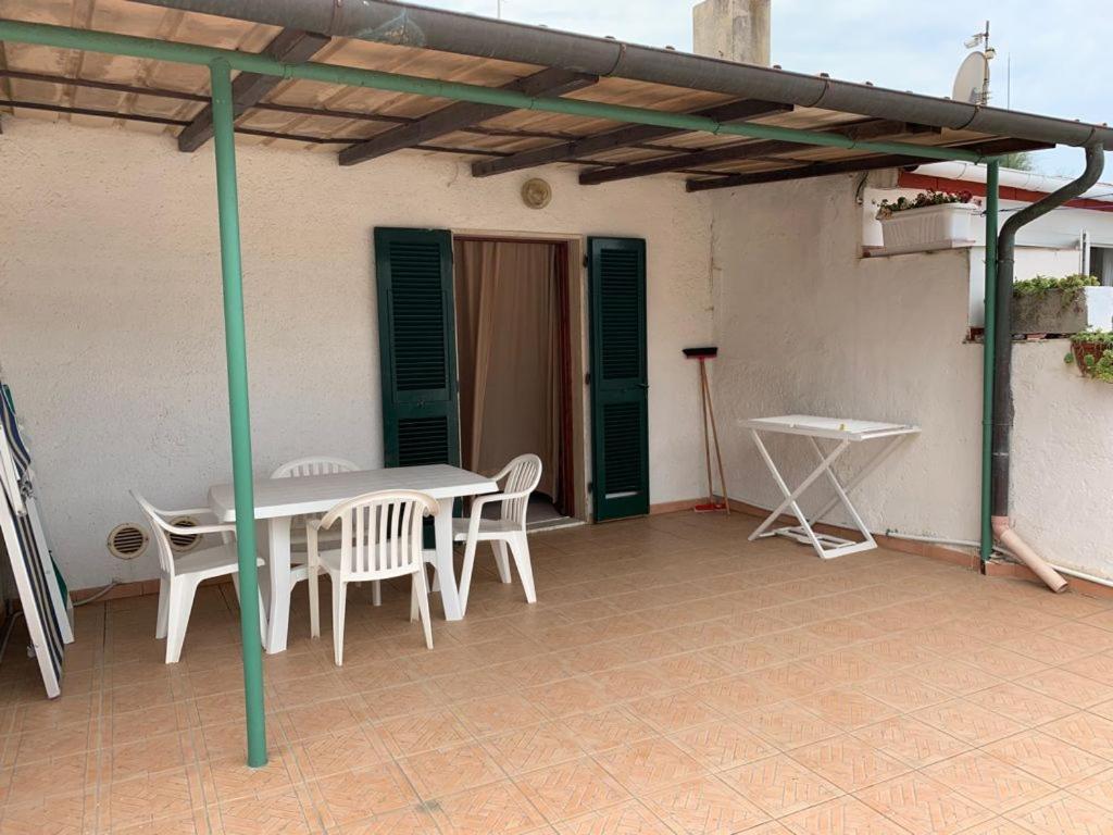 une terrasse avec une table et des chaises dans une maison dans l'établissement Appartamenti Villa Miramare, à Capoliveri