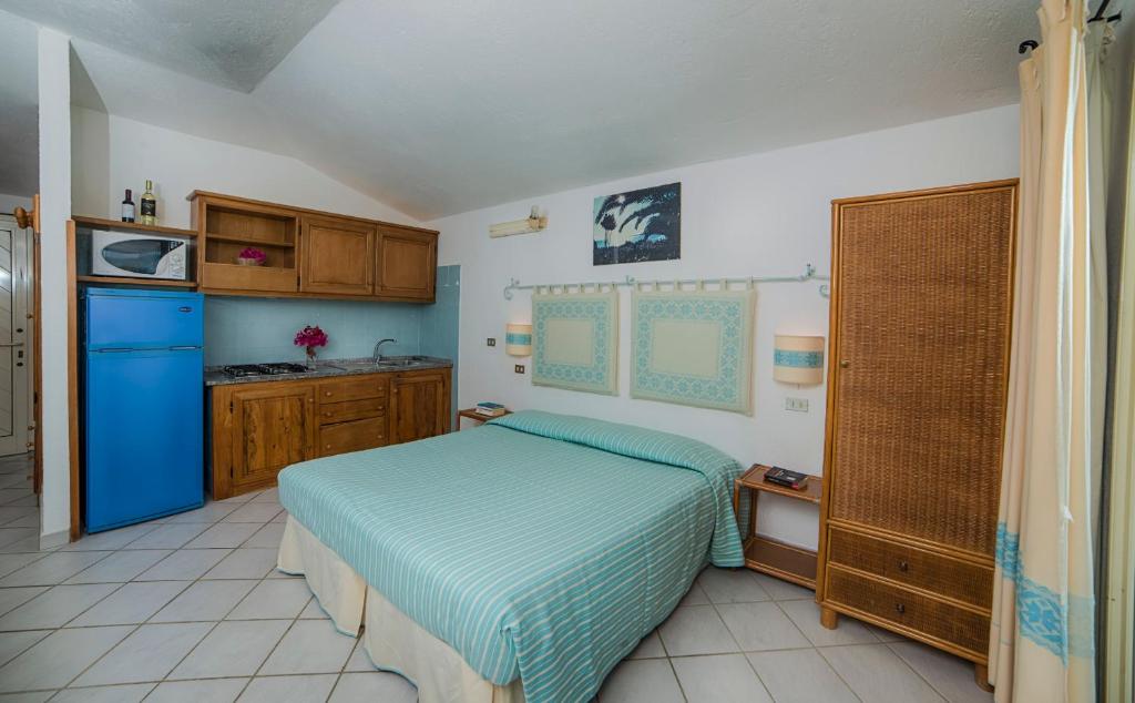 une chambre avec un lit et une cuisine dans l'établissement Residence Fenicia, à Villasimius