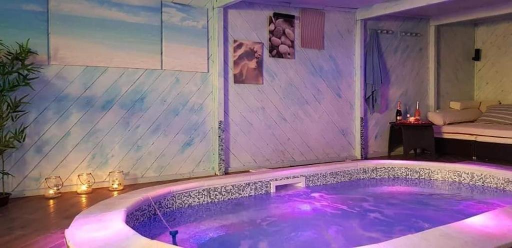 - un bain à remous dans une pièce avec éclairage violet dans l'établissement VILLA CARMEN, à Castel Volturno