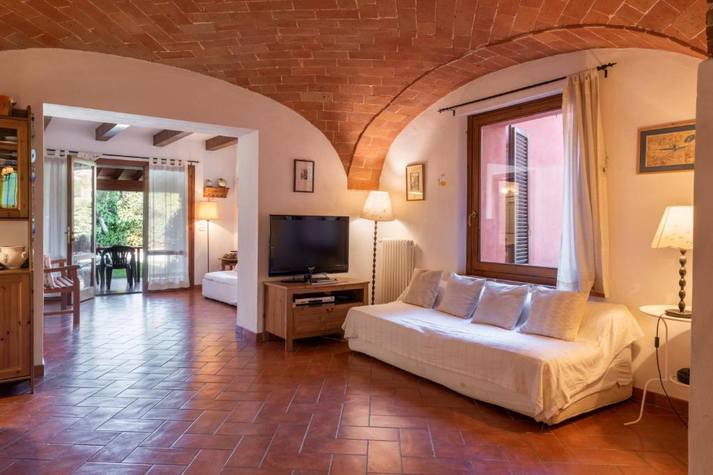 un salon avec un canapé et une télévision dans l'établissement Villa Rosina by Mmega, à Lucignano