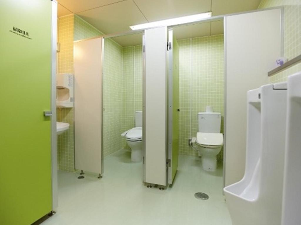 La salle de bains est pourvue de 2 toilettes et de 2 lavabos. dans l'établissement Kurplaza Pirika, à Hanaishi