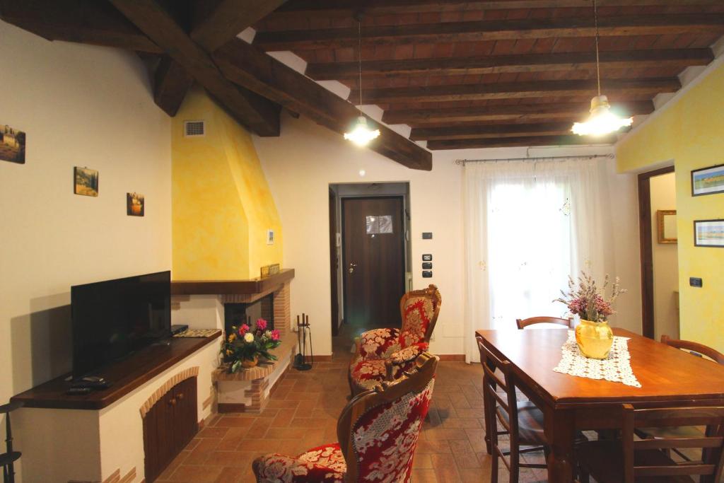 un salon avec une table, des chaises et une télévision dans l'établissement Villino Alba, à Pieve a Maiano