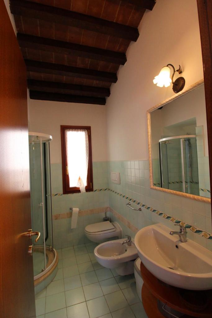 une salle de bain avec deux lavabos et un WC et un miroir dans l'établissement Villino Alba, à Pieve a Maiano