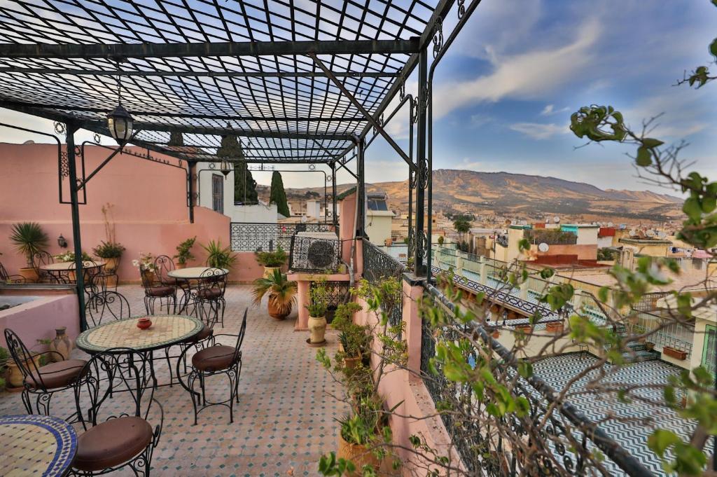 un patio avec tables et chaises sur un balcon dans l'établissement Riad Dar Chrifa, à Fès