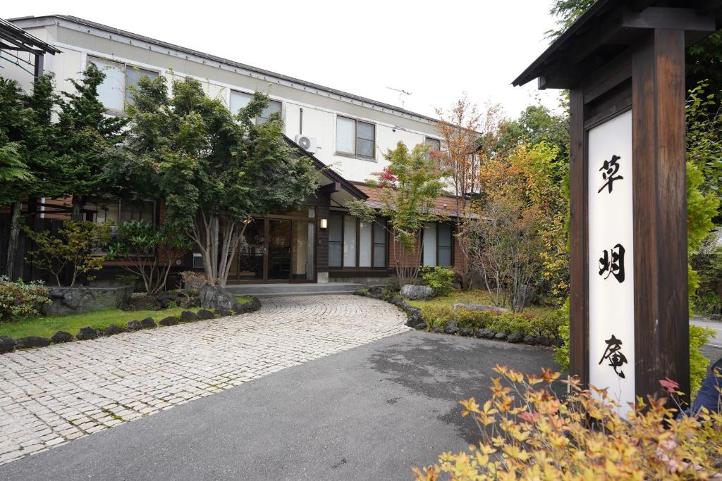 une maison avec des écrits asiatiques sur le côté de la route dans l'établissement Soumeian, à Kusatsu