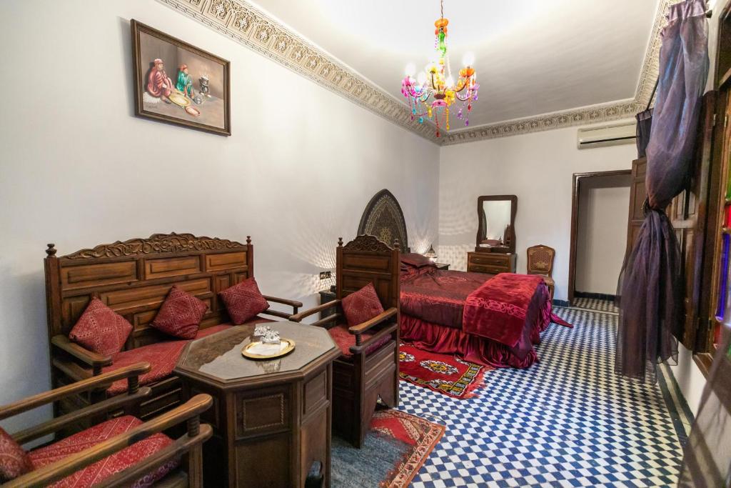 - une chambre avec deux lits, un lit et un canapé dans l'établissement Riad Dar Chrifa, à Fès