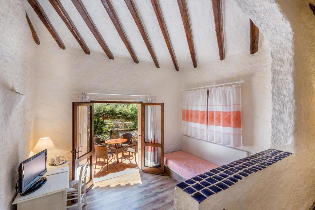 Cette chambre comprend un lit, une télévision et une table. dans l'établissement Hotel Don Diego, à Porto San Paolo 56 autres photos