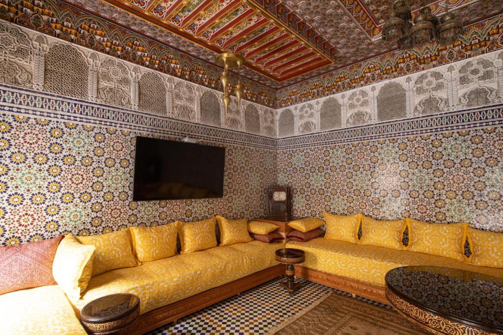 un salon avec un canapé jaune dans un mur dans l'établissement Riad Sayeda Al Hora, à Fès
