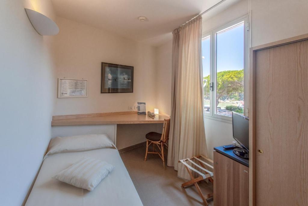 une chambre avec un lit, un bureau et une fenêtre dans l'établissement Hotel Desiree, à Procchio