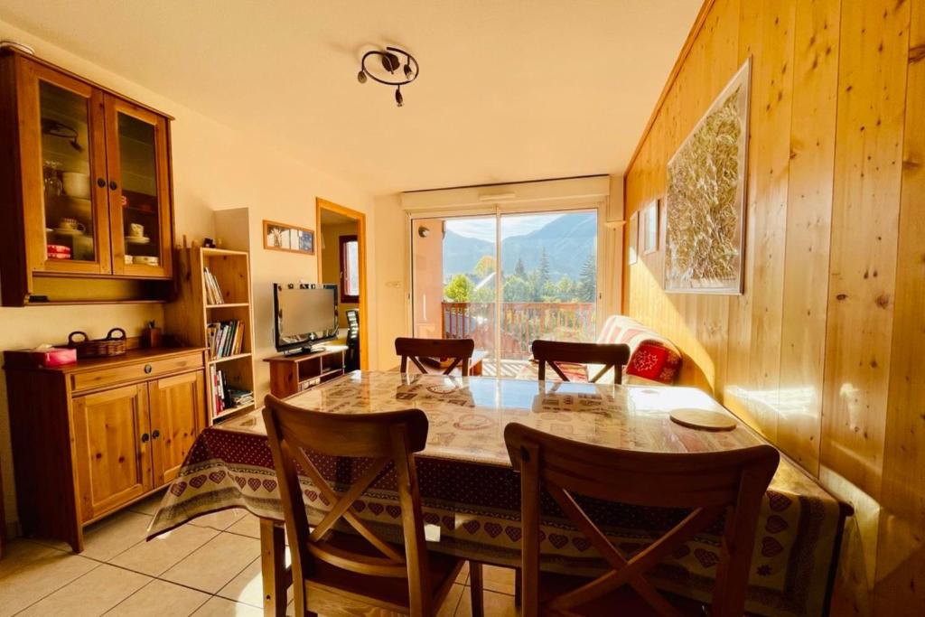 une cuisine avec une grande table et des chaises en bois dans l'établissement Nice Cosy Apt With Balcony In Briançon, à Briançon