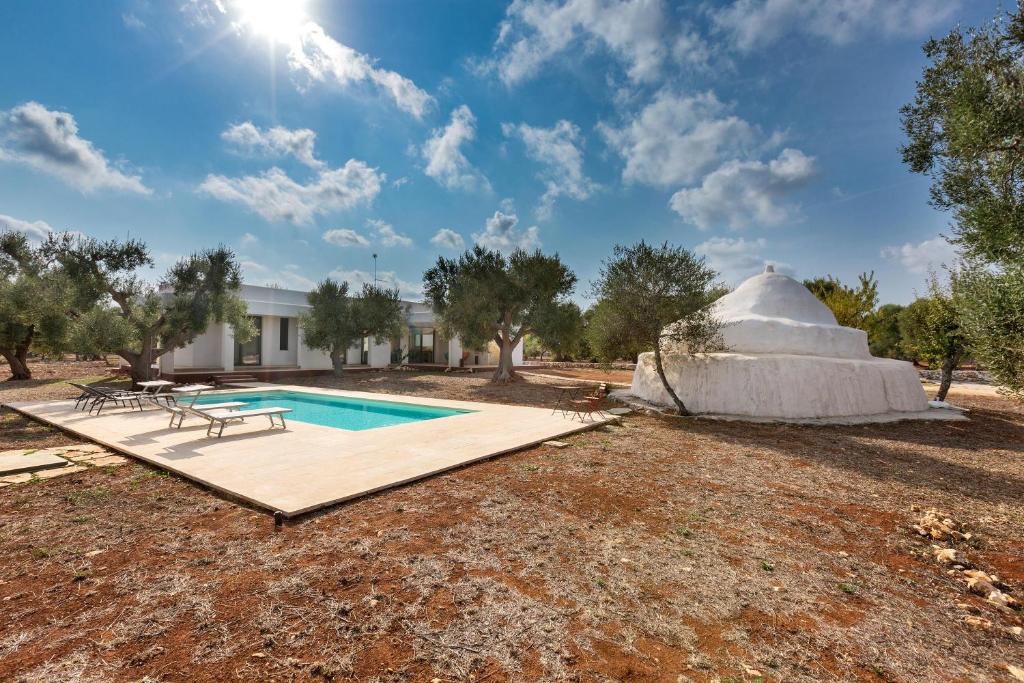 une maison en dôme avec une piscine dans une cour dans l'établissement Villa Magali' by Perle di Puglia, à Specchiolla