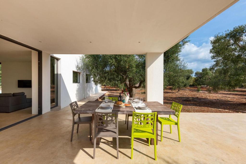une salle à manger avec une table en bois et des chaises jaunes dans l'établissement Villa Magali' by Perle di Puglia, à Specchiolla