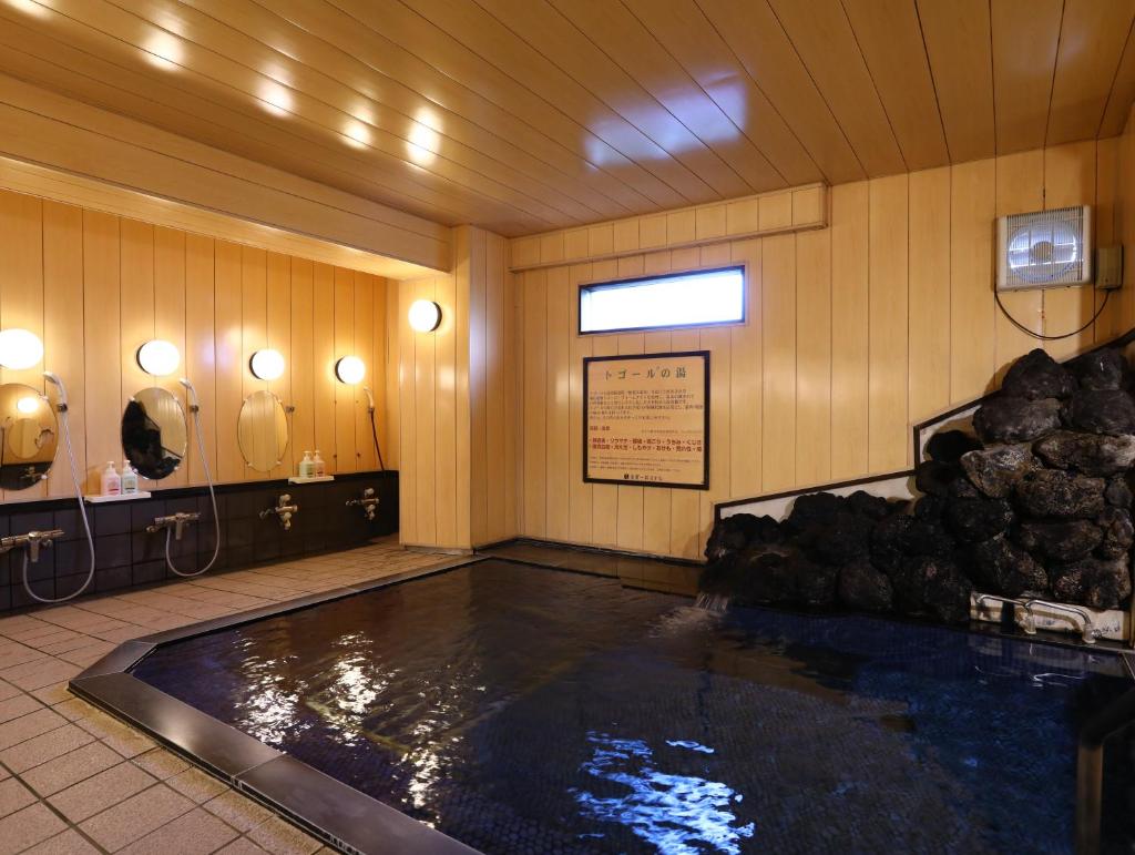 une grande piscine d'eau dans une pièce avec dans l'établissement Shiga Ichii Hotel, à Yamanouchi