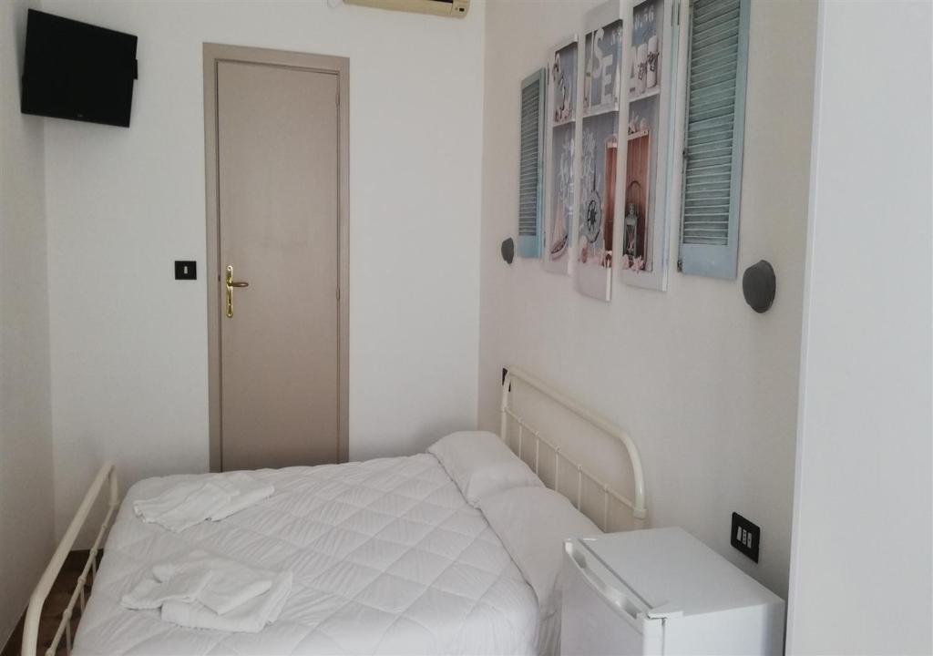 - une petite chambre blanche avec un lit et une télévision dans l'établissement Ahm7nani, à Mascali 5 autres photos