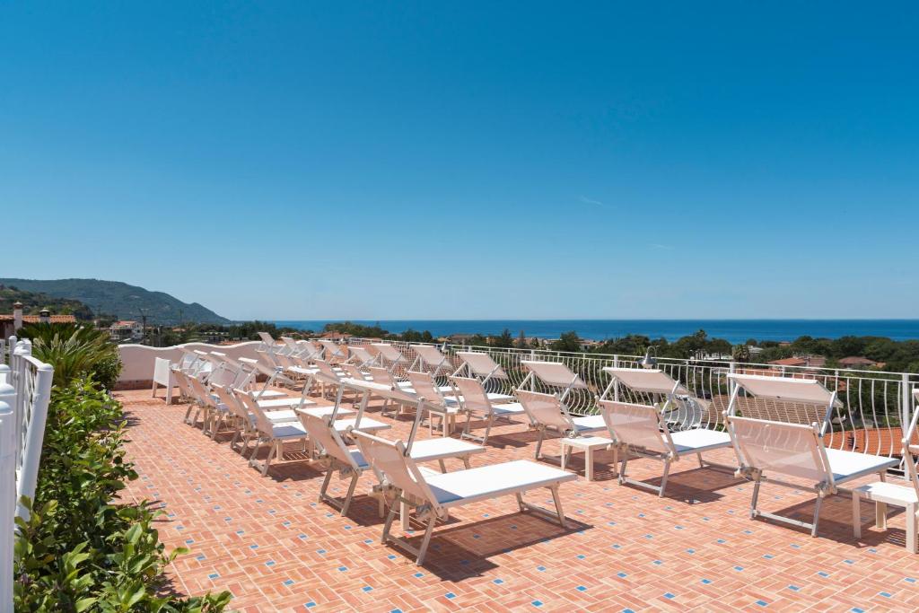 une rangée de chaises de jardin assises sur une terrasse dans l'établissement Hotel Ristorante Colleverde, à Santa Maria di Castellabate