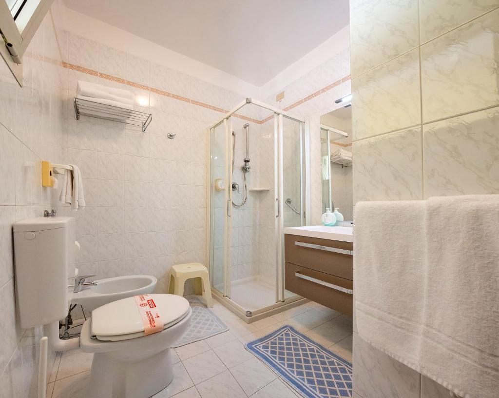 une salle de bain avec une douche, des toilettes et un lavabo dans l'établissement Hotel Marzia Holiday Queen, à Caorle