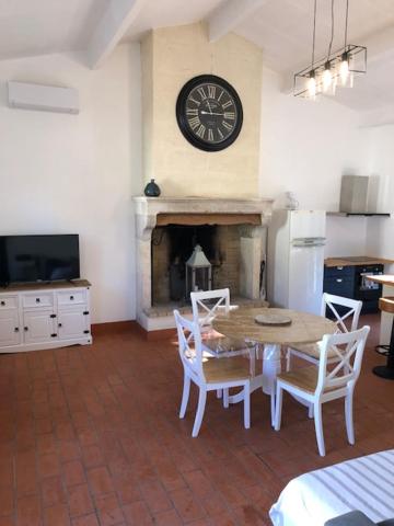 une salle à manger avec une table et une horloge au mur dans l'établissement Gite du Moulin de la Virvée, à Saint-André-de-Cubzac