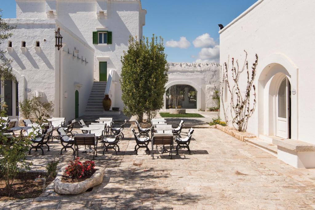 un patio avec tables et chaises dans un bâtiment dans l'établissement Masseria Il Melograno, à Monopoli