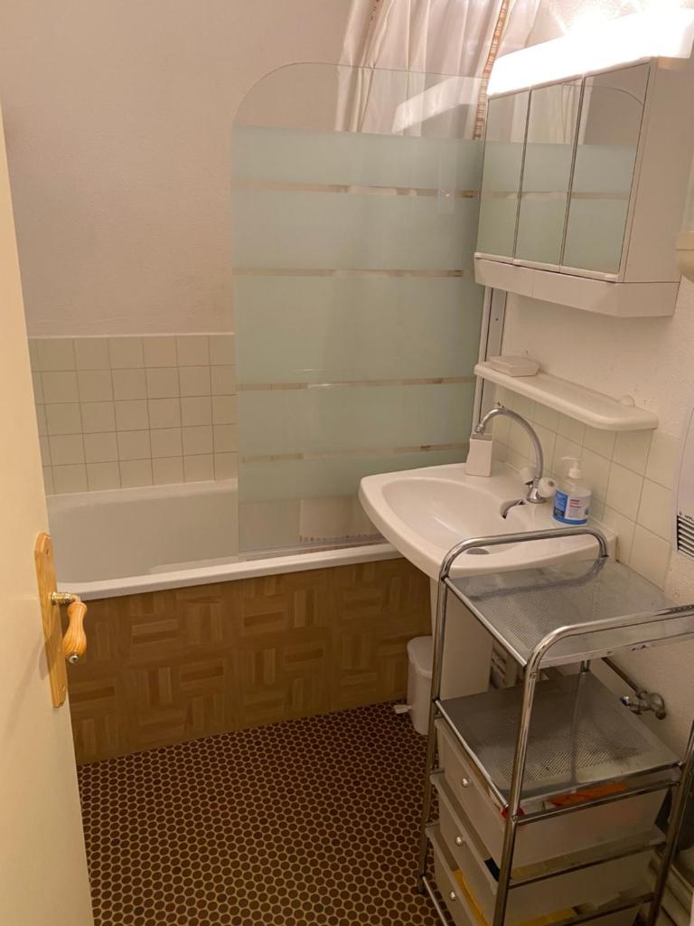 une salle de bain avec un lavabo, une baignoire et un miroir dans l'établissement Les Myrtilles Pyrénées 2000, à Bolquère-Pyrénées 2000