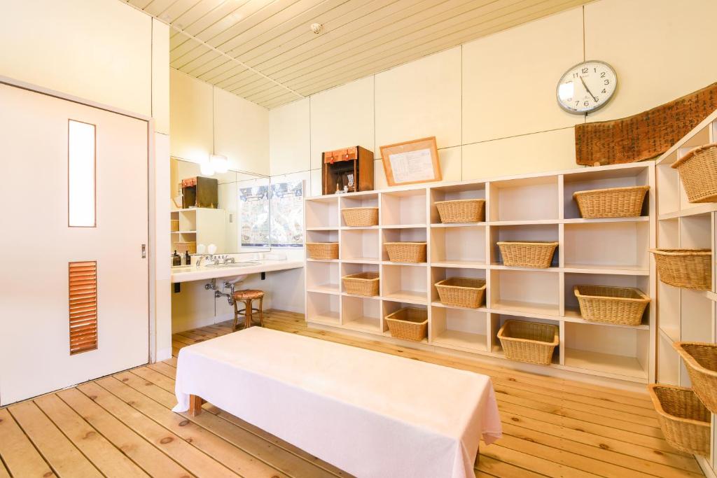 Cette chambre dispose d'une table blanche et d'étagères. dans l'établissement Yanagi No Yu, à Aomori