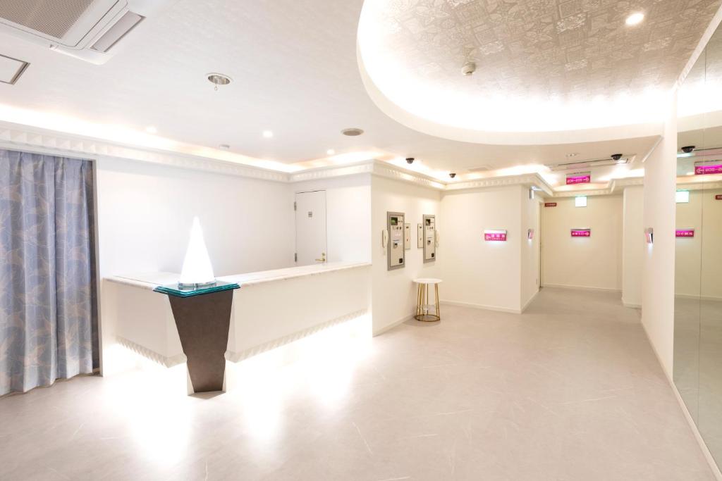 Cette chambre est dotée de murs blancs et d'un couloir avec une fenêtre. dans l'établissement Hotel Vega Takamatsu (Adult Only), à Takamatsu